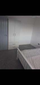 a bedroom with a bed and a white cabinet at Short and Long Night Stay - very close to Gatwick and City Centre - Private Airport Holiday Parking - Early Late Check-ins in Crawley