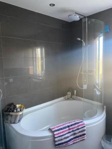 a bathroom with a bath tub with a towel on it at Short and Long Night Stay - very close to Gatwick and City Centre - Private Airport Holiday Parking - Early Late Check-ins in Crawley