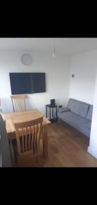 a living room with a wooden table and a couch at Short and Long Night Stay - very close to Gatwick and City Centre - Private Airport Holiday Parking - Early Late Check-ins in Crawley