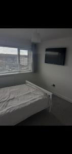 a white bedroom with a bed and a window at Short and Long Night Stay - very close to Gatwick and City Centre - Private Airport Holiday Parking - Early Late Check-ins in Crawley