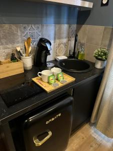 a kitchen with a black counter top with a sink at Le chalet montagne insolite avec spa et écran cinéma ! in Évreux