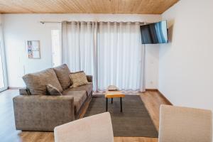 a living room with a couch and a tv at Forno House - Ameixoeira in Vila Praia de Âncora