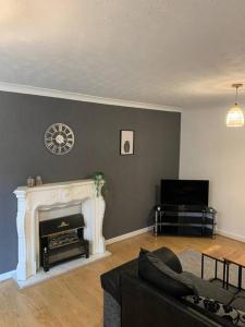a living room with a couch and a fireplace at Contractor Stays by Furnished Accommodation Manchester - Park Your Van on the Driveway with CCTV in Manchester
