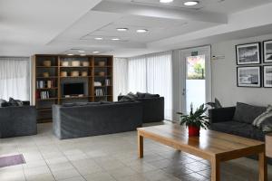 a living room with couches and a coffee table at O2 Hotel Villa Gesell in Villa Gesell