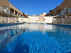 Casa en la playa con piscina في كوبيليس: مسبح فارغ فيه ماء ازرق في مبنى