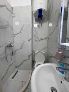 La salle de bains est pourvue d'un lavabo, d'une douche et de toilettes. dans l'établissement Arteg Apartments - Full Sea View, à Durrës