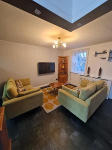 a living room with two couches and a flat screen tv at 3 bedroom apartment in Ulverston Cumbria in Ulverston