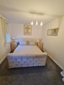 a bedroom with a large bed with two night stands at 3 bedroom apartment in Ulverston Cumbria in Ulverston