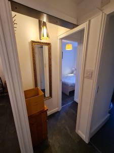 a hallway with a mirror and a bedroom with a bed at 3 bedroom apartment in Ulverston Cumbria in Ulverston