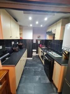 a large kitchen with white cabinets and black counter tops at 3 bedroom apartment in Ulverston Cumbria in Ulverston