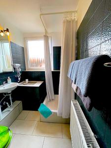 a bathroom with a shower and a sink and a tub at Hotel Uthoff in Bissendorf