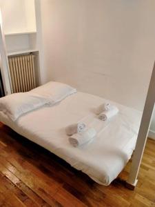 a bed with two rolls of paper towels on it at PARIS Vincennes authentique -`ღ in Vincennes