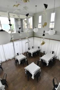 a room with white tables and chairs and windows at O2 Hotel Villa Gesell in Villa Gesell +28 photos