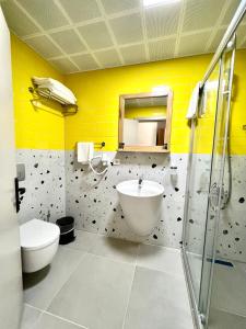 uma casa de banho com um lavatório, um WC e um espelho. em Hotel Panaya em Gokceada Town