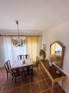 a dining room with a table and chairs and a mirror at The Early Bird - Cosy 2-Floor House with Garden in Alexandroupoli