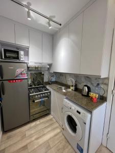 a kitchen with white cabinets and a washer and dryer at Property Sisters, Elite new studio B6 in Madinaty