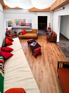 a living room with two large couches and a living room with wooden floors at Ancestral Hostel in Bogotá