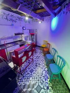 a room with a kitchen with chairs and a piano at Ancestral Hostel in Bogotá