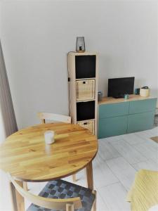 a kitchen with a wooden table and a refrigerator at Studio La Grande Motte, au plus près des plages in La Grande Motte
