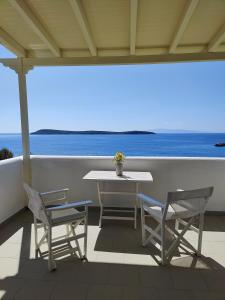 stół i krzesła na balkonie z widokiem na ocean w obiekcie Kleanthi Apartments w mieście Drios