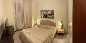 a small bedroom with a bed and a television at Romeo Apartment in Livorno
