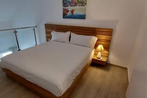 a bedroom with a large bed and a lamp at Duplex moderne vue mer des caraibes in Marigot +11 photos