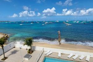 a view of a beach with boats in the water at Duplex moderne vue mer des caraibes in Marigot