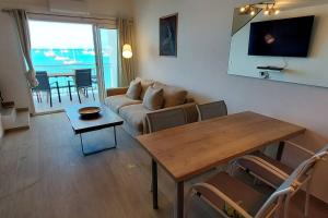 a living room with a table and a couch at Duplex moderne vue mer des caraibes in Marigot