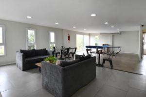 a living room with couches and a ping pong table at O2 Hotel Villa Gesell in Villa Gesell