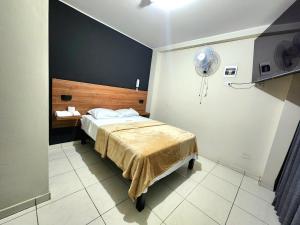 Habitación de hotel con cama y ventilador en HOSTAL IMH, en Lima