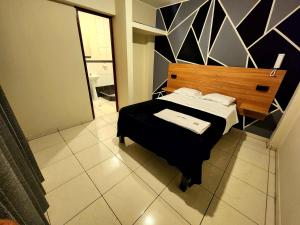 1 dormitorio con 1 cama con cabecero de madera en HOSTAL IMH, en Lima
