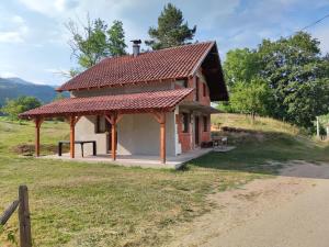 a small building with a red roof on a field at Dolina Plive in Jezero +7 photos
