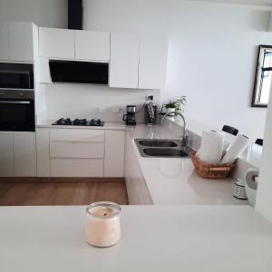 a white kitchen with white cabinets and a sink at CASA DE MARIA in Cancún