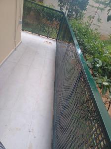 a chain link fence in front of a walkway at Cozy Renovated Apartment in Athens