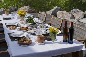 a long table with wine bottles and plates of food at Sami Mta Chalet in Mestia
