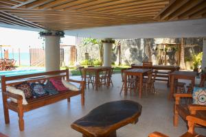 a patio with tables and chairs and a couch at Apartamento a Beira Mar no Flat Elegance in Natal