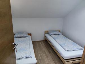 two beds in a small room with a door at Dolina Plive in Jezero