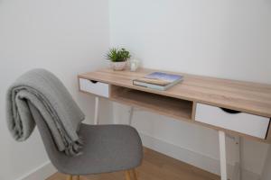 a wooden desk with a chair and a book at Brand New Luxury 1 Bed 2 Bath Apartment - SPA, Pool & Gym in Gibraltar