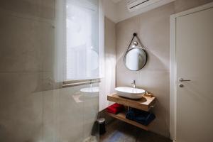 W łazience znajduje się umywalka i lustro. w obiekcie Dimore Dalle Zie w Alberobello