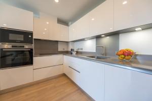 uma cozinha branca com uma taça de fruta no balcão em Brand New Luxury 1 Bed 2 Bath Apartment - SPA, Pool & Gym em Gibraltar