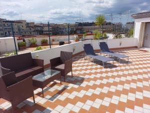 patio z krzesłami i stołami na dachu w obiekcie Raggio di sole w mieście Napoli