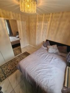 a bedroom with a large bed and a mirror at Shaz,s House in Cowley