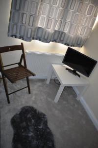 a room with a desk and a chair and a computer at Shaz,s House in Cowley