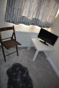 a room with a desk and a chair and a computer at Shaz,s House in Cowley +12 photos