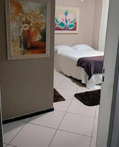 a bedroom with a bed and a white tiled floor at Pousada Central in São Benedito