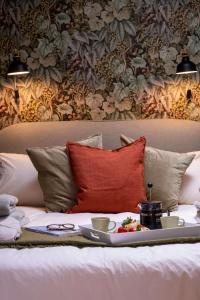 a couch with a table with a red pillow and cups at The Nest in Brockenhurst