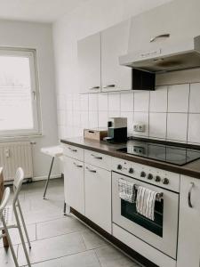a white kitchen with a stove and a sink at Zentral, geräumig, Messe nah! BE2R in Essen
