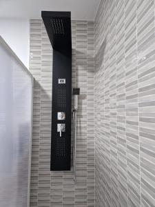 W łazience z czarno-białą ścianą znajduje się prysznic. w obiekcie Apartamento mi currilla w mieście Sanlúcar de Barrameda