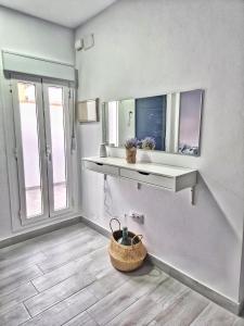 Habitación blanca con estante y espejo en Apartamento mi currilla, en Sanlúcar de Barrameda