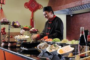 a man in a kitchen preparing food on a counter at New Madinah Hotel in Al Madinah